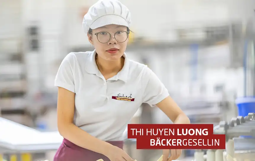 Hier siehst du eine vietnamesische Bäckergesellin, die konzentriert bei ihrer Arbeit in der Konditorei aufschaut.